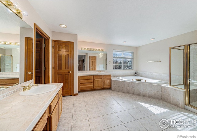 bathroom with a shower stall, a garden tub, two vanities, tile patterned floors, and a sink