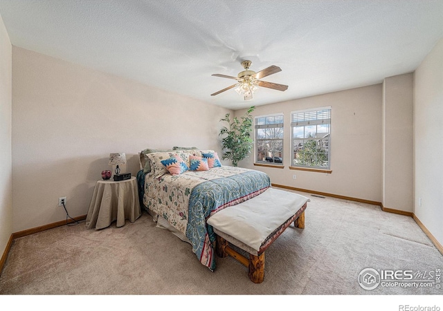 bedroom featuring carpet, visible vents, baseboards, ceiling fan, and a textured ceiling