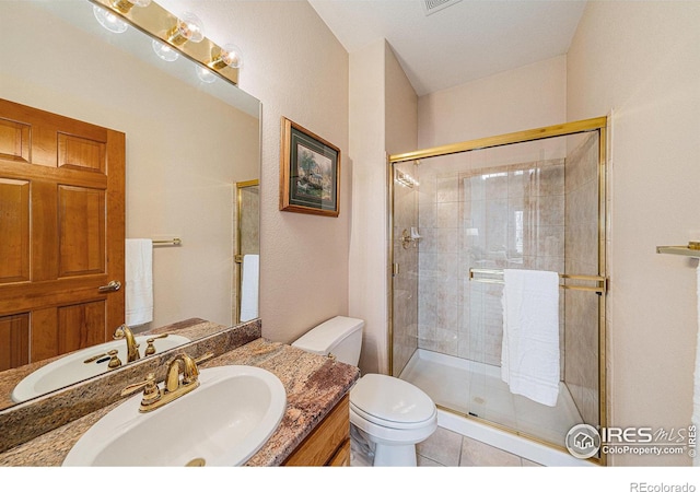 bathroom with tile patterned floors, vanity, toilet, and a shower stall