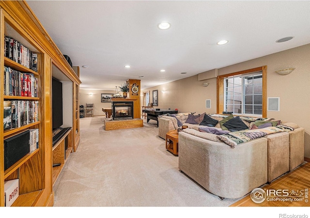 carpeted living room featuring a multi sided fireplace and recessed lighting