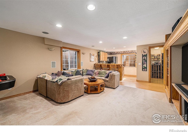 carpeted living area with recessed lighting, visible vents, baseboards, and a textured ceiling