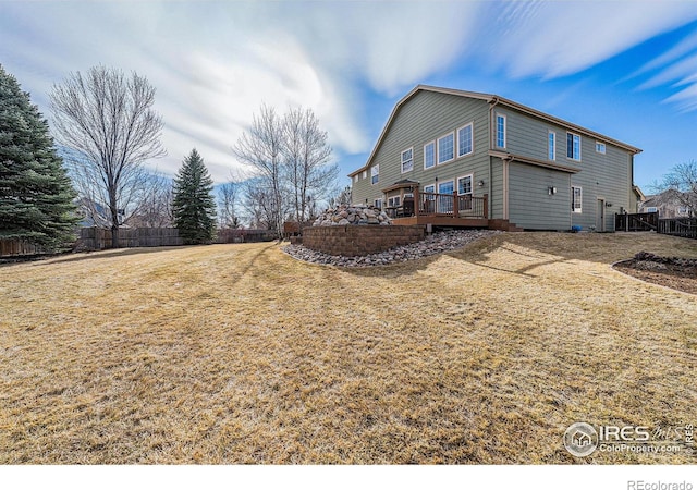 view of property exterior featuring a yard, a deck, and a fenced backyard