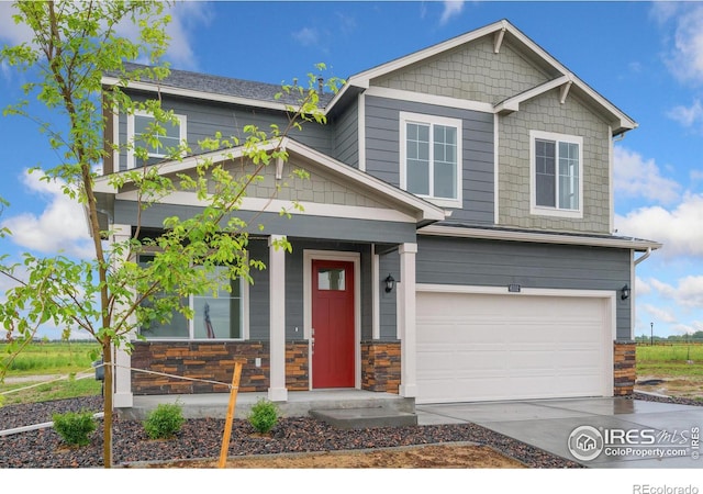 craftsman house featuring a garage, stone siding, a porch, and driveway