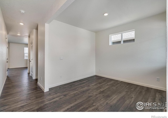 unfurnished room with recessed lighting, dark wood-style floors, and baseboards