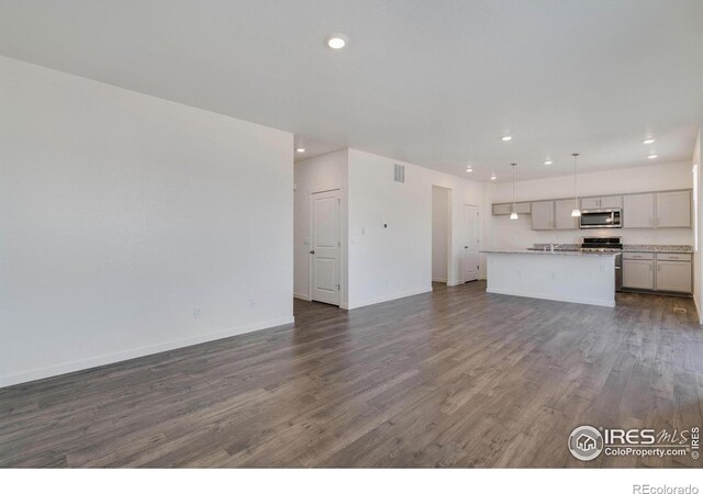 unfurnished living room with visible vents, recessed lighting, baseboards, and dark wood-style flooring