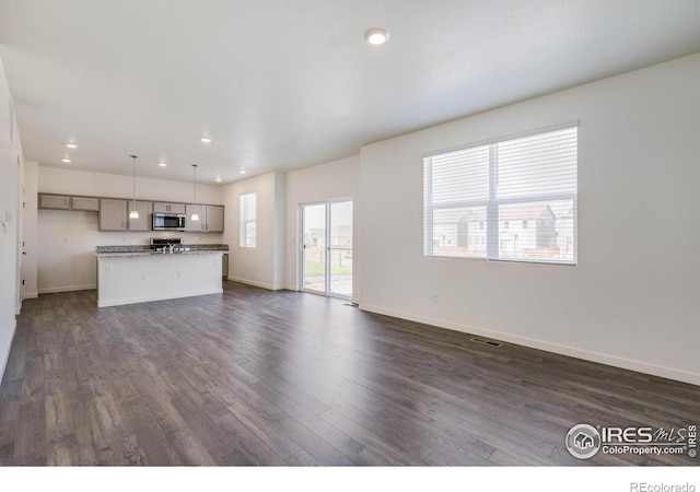 unfurnished living room featuring visible vents, recessed lighting, dark wood-type flooring, and baseboards