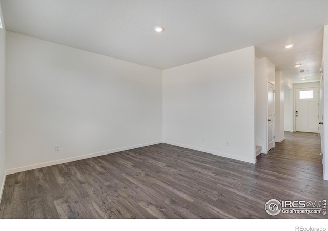 unfurnished room featuring recessed lighting, dark wood-style floors, and baseboards