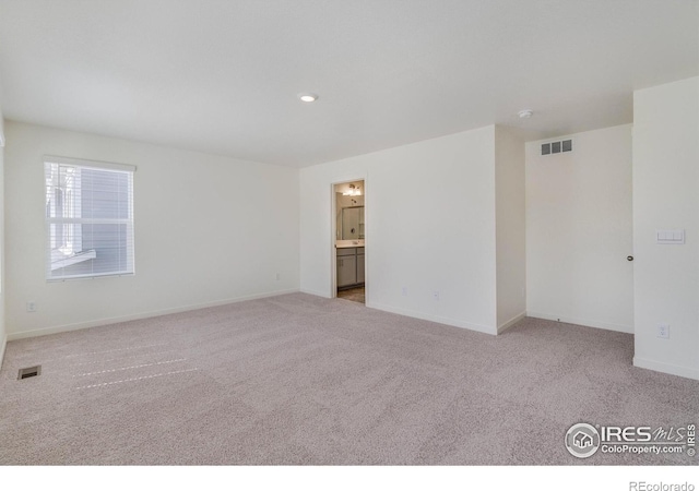 spare room featuring visible vents, baseboards, and carpet