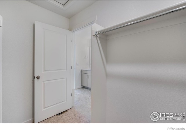 walk in closet with light carpet and visible vents