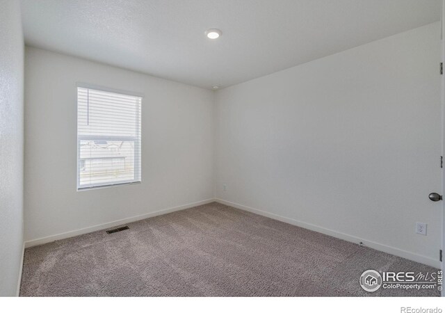 unfurnished room featuring visible vents, baseboards, and carpet