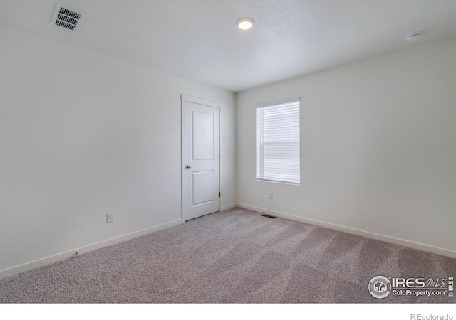 carpeted empty room with visible vents and baseboards