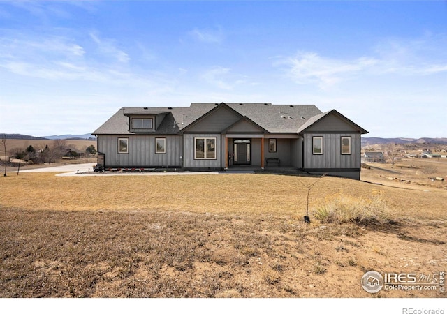 modern inspired farmhouse featuring a mountain view, roof with shingles, and board and batten siding