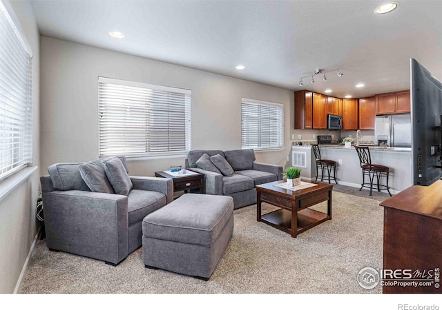 living area with light carpet, recessed lighting, rail lighting, and baseboards