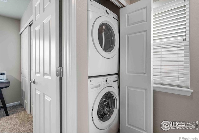 laundry room featuring stacked washer / dryer, laundry area, and carpet