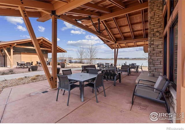 view of patio / terrace featuring a gazebo, outdoor dining area, and a water view