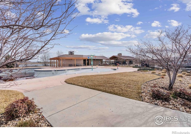 exterior space featuring a yard, fence, a patio, and a community pool