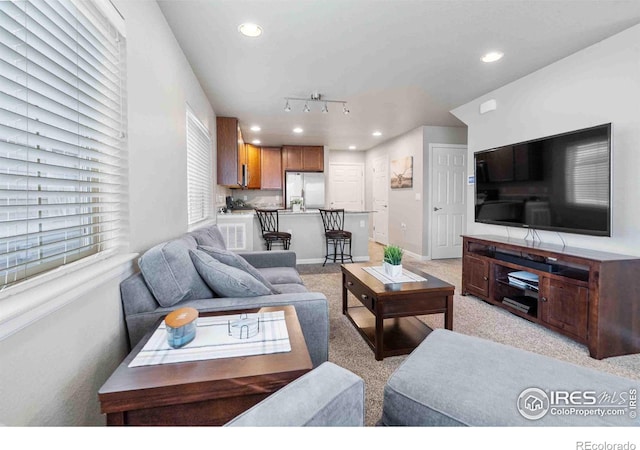 living area featuring recessed lighting, baseboards, and light carpet