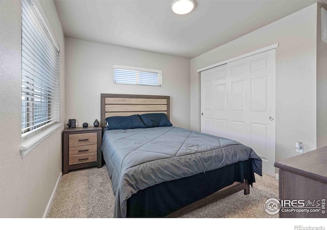 bedroom with a closet, carpet floors, and baseboards