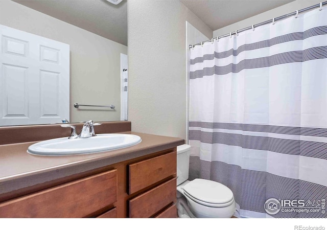 bathroom with a shower with shower curtain, toilet, and vanity