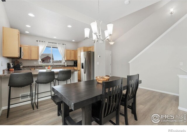 dining room featuring recessed lighting, light wood-type flooring, baseboards, and a chandelier