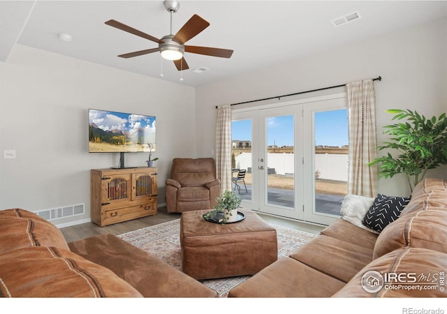 living room featuring visible vents, a ceiling fan, and wood finished floors