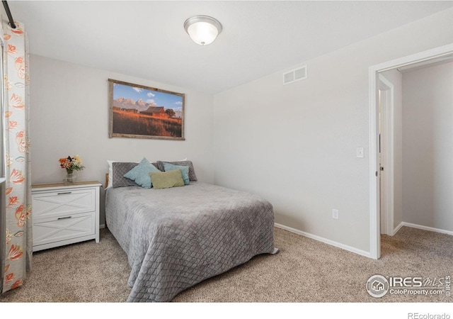 bedroom featuring visible vents, light carpet, and baseboards