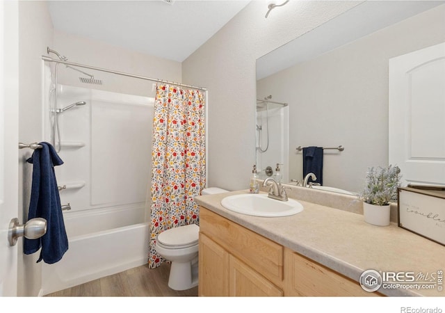 bathroom with visible vents, toilet, wood finished floors, shower / bath combination with curtain, and vanity