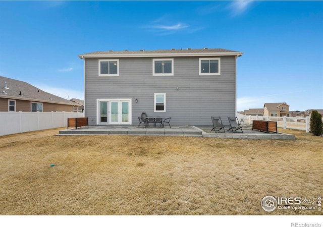 back of house featuring a fenced backyard, a lawn, french doors, and a patio