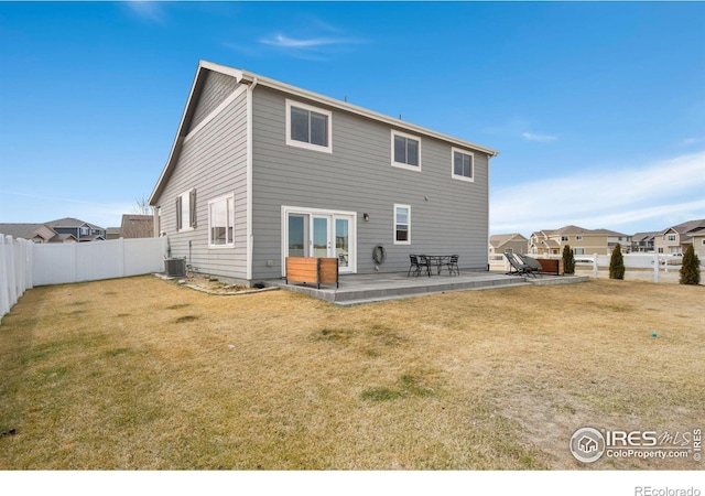 rear view of house featuring a yard, central AC, a fenced backyard, and a patio area