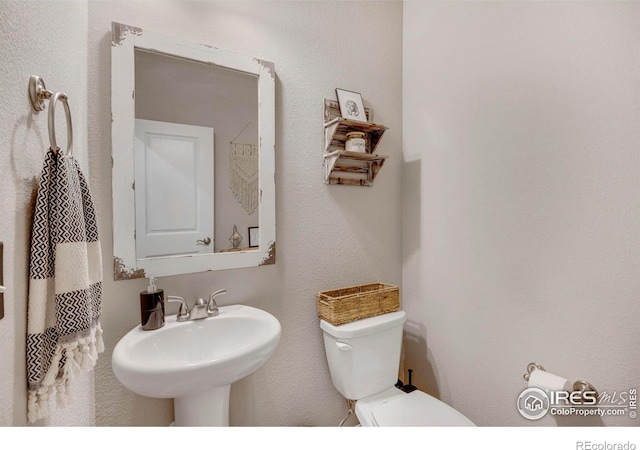 half bathroom featuring a sink and toilet