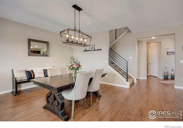 dining space featuring stairs, baseboards, and wood finished floors