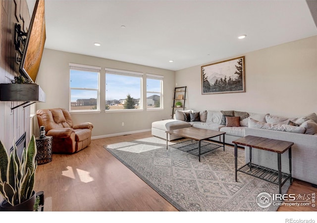 living area featuring recessed lighting, wood finished floors, and baseboards