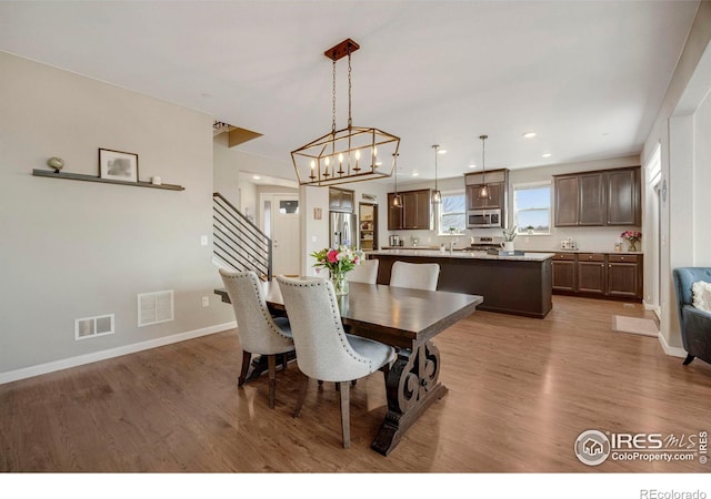 dining room featuring wood finished floors, visible vents, and baseboards