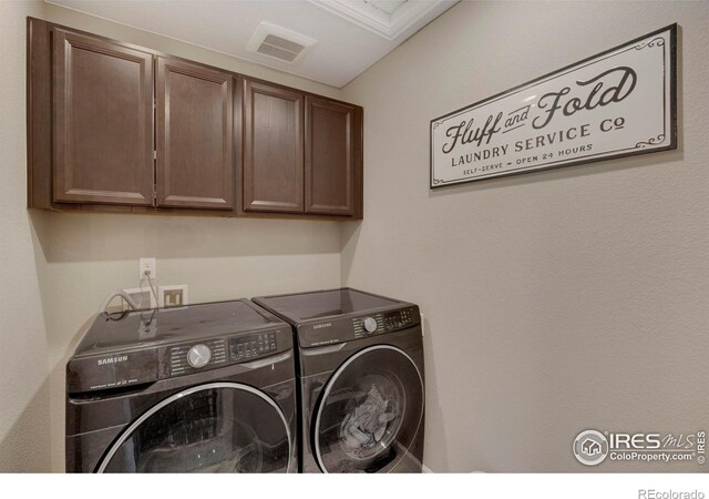 laundry area with cabinet space, visible vents, and washer and clothes dryer