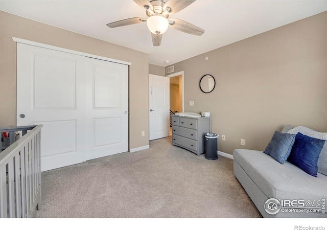 living area featuring baseboards, light colored carpet, and a ceiling fan