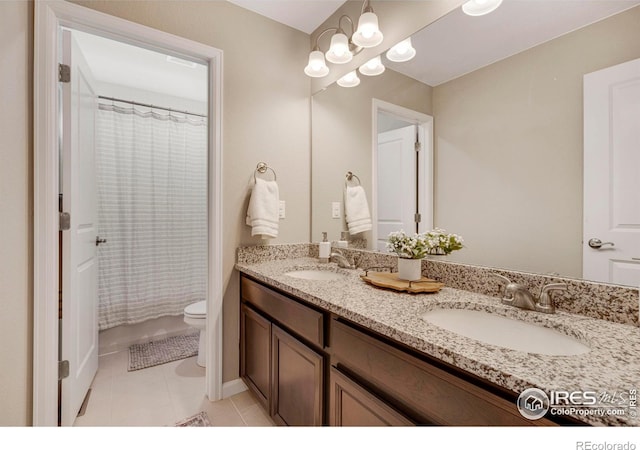 bathroom featuring tile patterned flooring, double vanity, toilet, and a sink