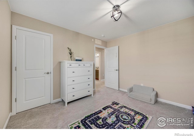 bedroom featuring light carpet, visible vents, and baseboards