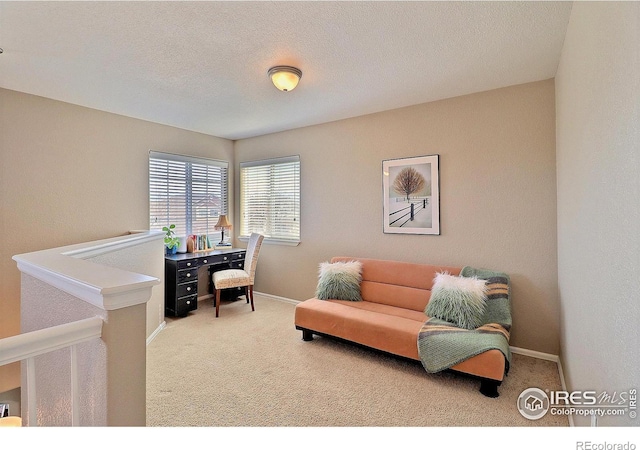 carpeted office with baseboards and a textured ceiling