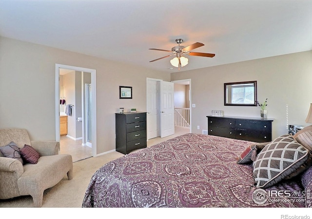 bedroom with baseboards, light carpet, ensuite bath, and a ceiling fan