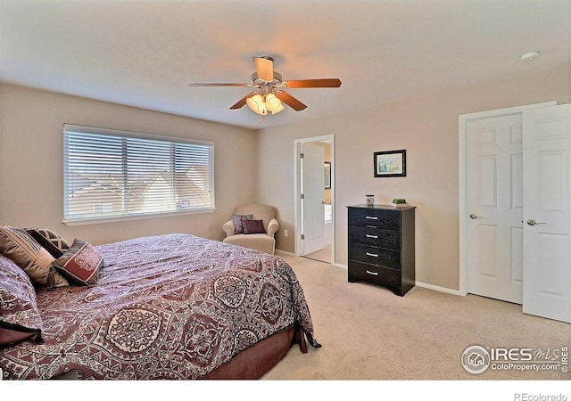 carpeted bedroom featuring ceiling fan, connected bathroom, and baseboards