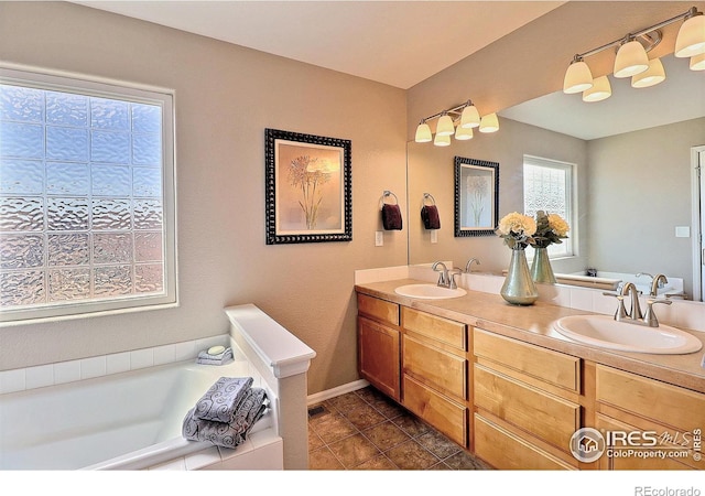 full bathroom with tile patterned flooring, double vanity, a bath, and a sink