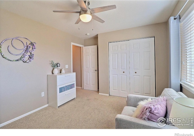 sitting room featuring light colored carpet, baseboards, and ceiling fan