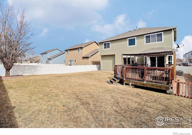 back of house featuring a wooden deck, a lawn, a garage, and a fenced backyard