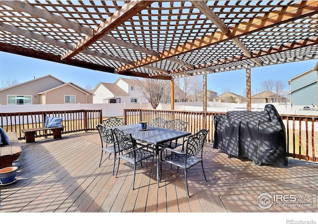 wooden deck with a residential view, outdoor dining area, a fenced backyard, and area for grilling