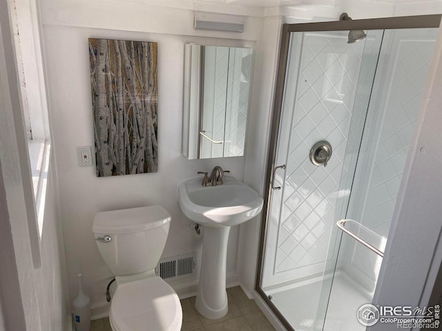 bathroom featuring visible vents, toilet, a shower stall, and tile patterned flooring