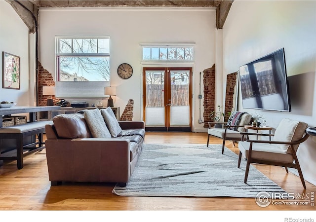 living room featuring wood finished floors, a high ceiling, and french doors