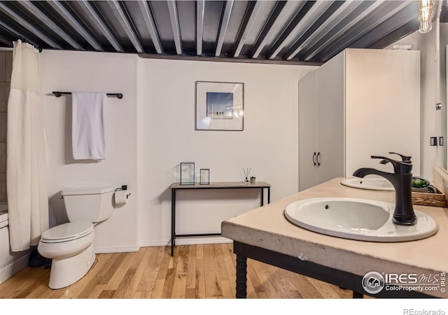 full bathroom featuring a sink, toilet, and wood finished floors