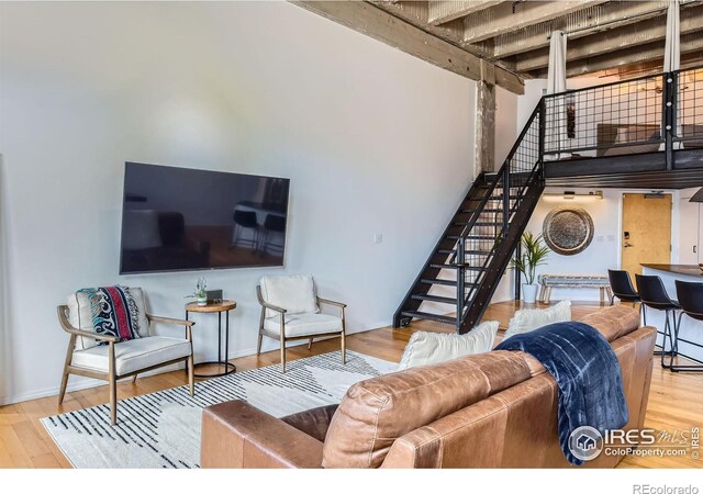 1000 E 18th Ave, Denver, CO 80218 - living room with stairway, wood finished floors, a towering ceiling, beamed ceiling, and baseboards