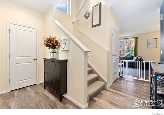 staircase with baseboards and wood finished floors