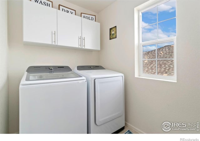 laundry area featuring cabinet space, baseboards, and separate washer and dryer